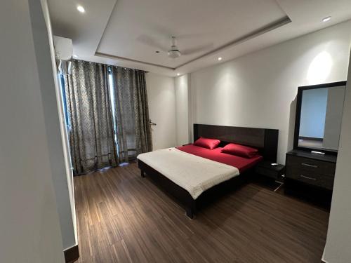 a bedroom with a bed and a flat screen tv at The Gulberg Apartments in Lahore