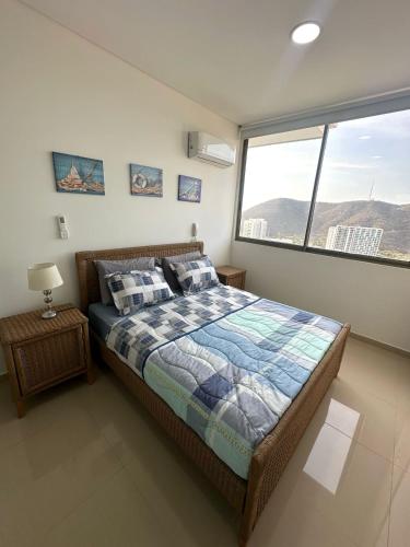 sypialnia z łóżkiem i dużym oknem w obiekcie Apartamento completo en Club de Playa en Santa Marta w mieście Santa Marta