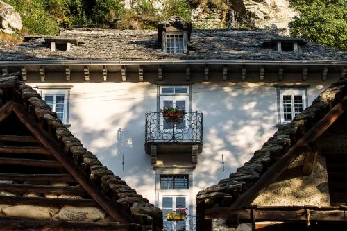 a house with a balcony and a sky at Palazzo Gamboni Swiss Historic Hotel in Comologno