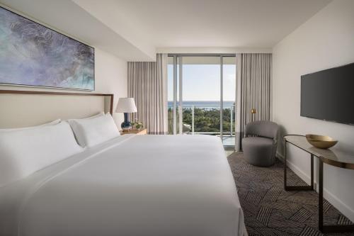 a hotel room with a large bed and a television at The Ritz-Carlton Residences, Waikiki Beach Hotel in Honolulu