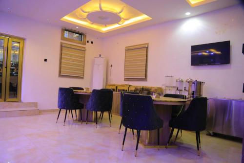 a dining room with chairs and a table in a room at Triple J Universal Hotel and Suites in Asaba