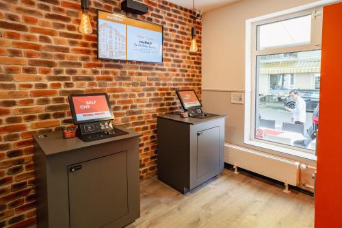 a room with a brick wall and a cash register at easyHotel Zürich City Main Station in Zürich