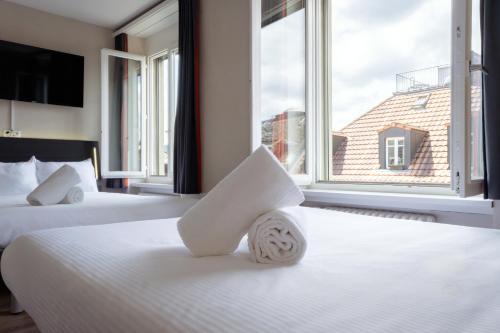 a hotel room with two beds and a large window at easyHotel Zürich City Main Station in Zürich