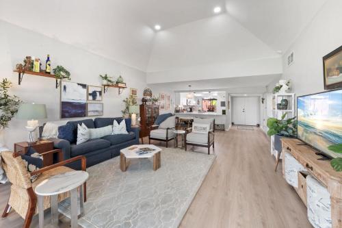 a living room with a blue couch and a tv at Designer Seville Condo w Golf Mountain Views in Rancho Mirage