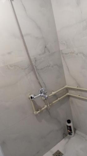 a bathroom with a shower with white marble walls at Kuca pored rijeke Kurikuce RiversideHomeKurikuce in Berane