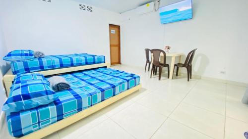 a bedroom with two beds and a table and chairs at Mayo Habitación Tolu in Tolú