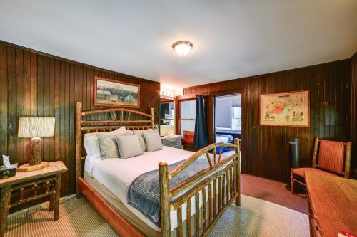 a bedroom with a bed and a table and a chair at Hatchs Landing Lake Ostego Home in Cooperstown