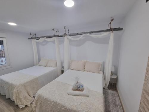 two beds in a room with white walls at Casiña Fina in Porriño