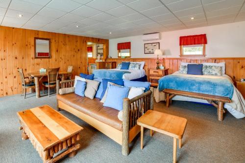 a bedroom with two beds and a couch and a table at The Nest Waterfront Lake Ostego Studio in Cooperstown