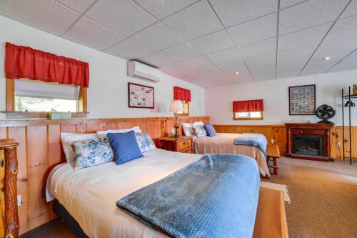 a bedroom with two beds and a fireplace at The Nest Waterfront Lake Ostego Studio in Cooperstown