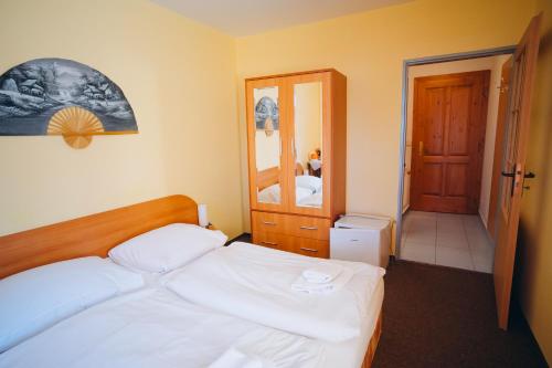 a small bedroom with a bed and a mirror at Penzion Vyhlídka Janovičky in Broumov