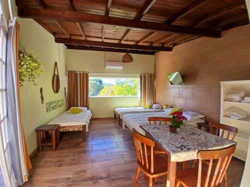 a room with four beds and a table and chairs at Solar del Mar in Praia do Rosa