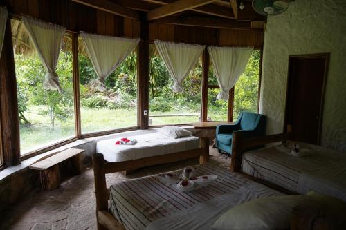 a bedroom with two beds and a chair and a window at Eco Hotel Sak Nok in Lacanjá