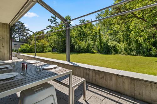 an outdoor patio with a table and a large window at Maison à Portalban - 5 pers, 3 lits, jardin & terrasse in Portalban- Dessous