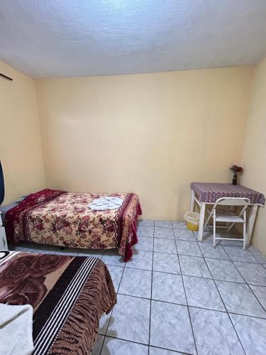 a room with two beds and a table at Hospedaje El Paraíso in San Pedro La Laguna