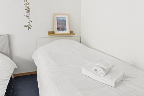 a white bed with two white towels on it at Maison à Portalban - 5 pers, 3 lits, jardin & terrasse in Portalban- Dessous