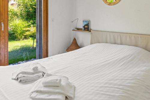 a bedroom with a white bed with towels on it at Maison à Portalban - 5 pers, 3 lits, jardin & terrasse in Portalban- Dessous