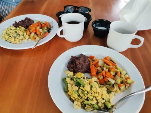 una mesa con dos platos de comida y dos tazas de café en Zensus Laguna, en Bacalar