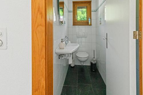 a white bathroom with a sink and a toilet at Maison à Portalban - 5 pers, 3 lits, jardin & terrasse in Portalban- Dessous