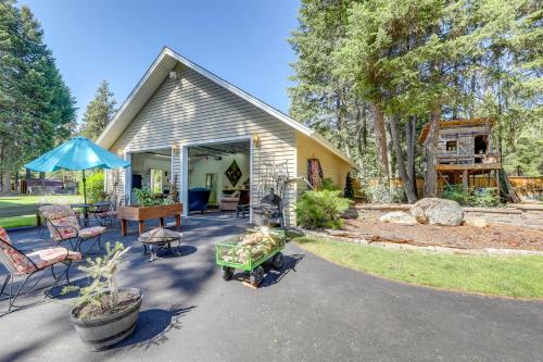 a house with a patio with chairs and an umbrella at Walk to Happys Inn Studio with Outdoor Space! in Libby
