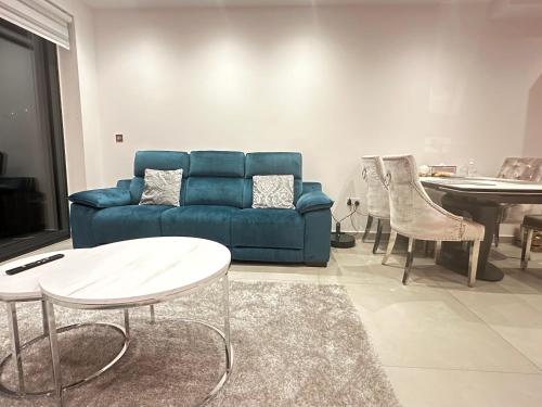 a living room with a blue couch and a table at Kilby close in Edgware