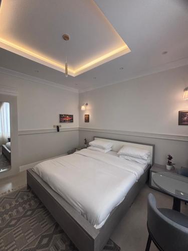 Un dormitorio con una cama blanca grande y un escritorio en Modern studio, en Yeda
