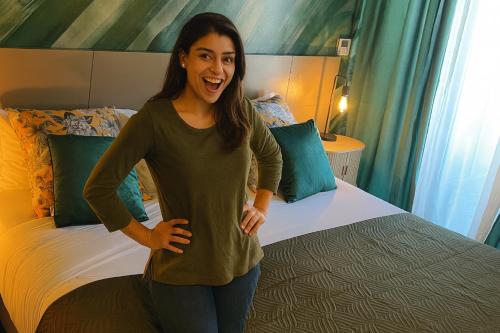 a woman is standing in front of a bed at BE ONE HOTEL Caldas da Rainha - by MHMB Hospitality in Caldas da Rainha