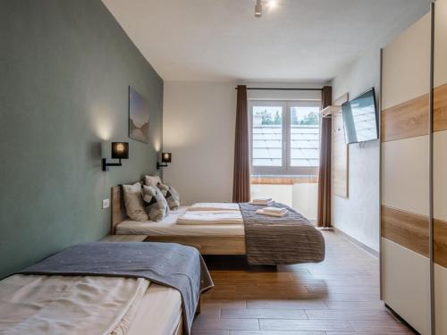 ein Schlafzimmer mit zwei Betten und einem Fenster in der Unterkunft Emma Top 1 XL in Dienten am Hochkönig