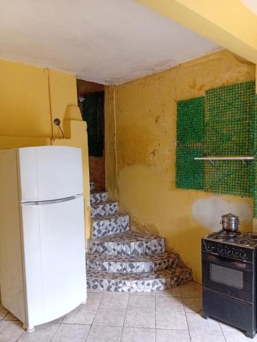 a kitchen with a white refrigerator and a stove at Hostel One Love Lençois in Lençóis
