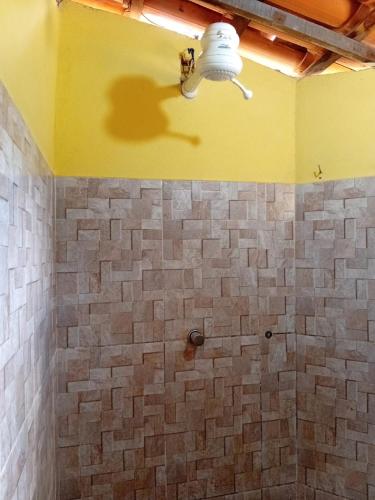 a bathroom with a tiled shower with a light at Hostel One Love Lençois in Lençóis