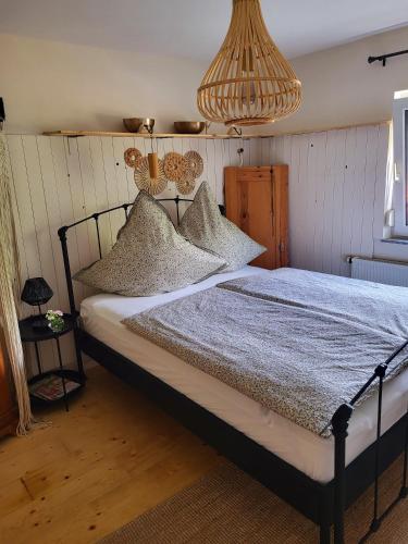 a bedroom with a bed with pillows and a chandelier at Ferienwohnung Schwarzwaldglück in Baiersbronn
