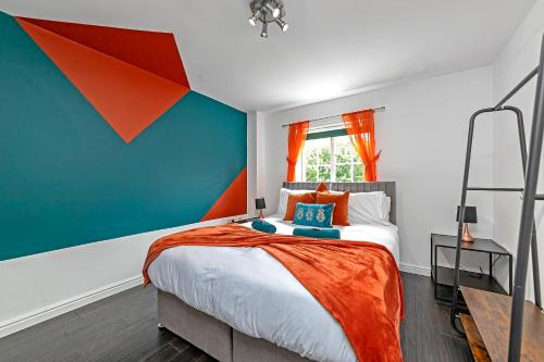 a bedroom with a large bed with an orange blanket at Luxury Apartment-CONTRACTORS-Free Parking-Central Location in Luton