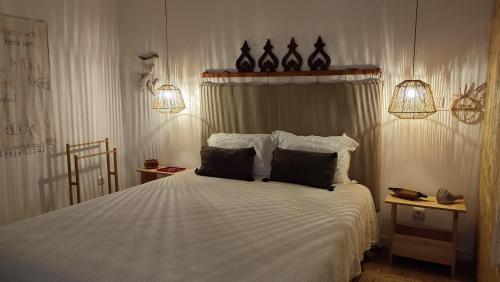 a bedroom with a large white bed with two pillows at Casa Hurtere in Horta