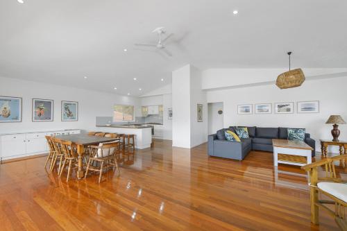 a living room and dining room with a couch and a table at Vaka Malua 7 Scott Street in Crescent Head