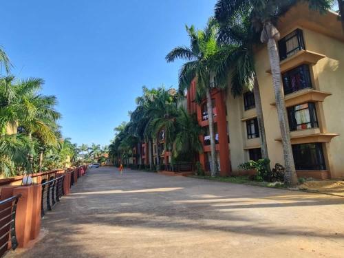 a street with palm trees next to a building at Spring Hills Apartment in Kampala in Kampala