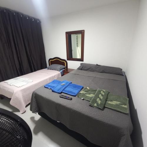 巴西利亚Apartamento 1 quarto Asa Norte prédio misto - residencial comercial - wi-Fi - 1 a 3 hospedes - sem taxas的有两张床和一面镜子的卧室
