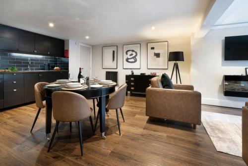 a kitchen and dining room with a table and chairs at Courtyard Apartments in Bowness-on-Windermere