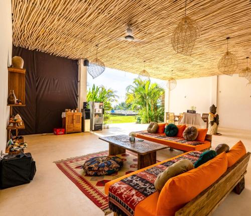 a living room with orange couches and a table at Sukacita Hill in Uluwatu