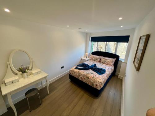 a bedroom with a bed and a dressing table and a mirror at Bournemouth Nest in Bournemouth