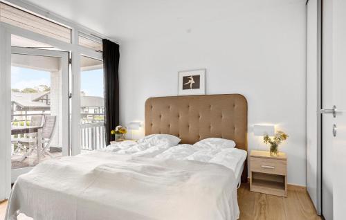 a white bedroom with a large bed and a balcony at Gorgeous Home In Gråsten With Sauna in Gråsten