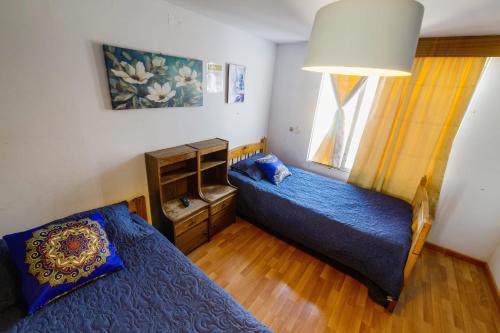 a bedroom with two beds and a window at Hostal Pampaloja Antof in Antofagasta