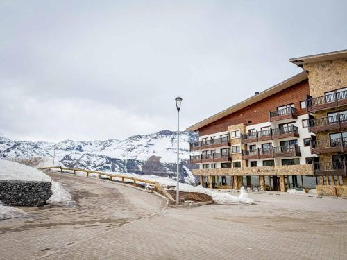 a building with a snow covered mountain in the background at HOM I SKI OUT 4PAX Edif Licancabur Valle Nevado 206A in Lo Barnechea