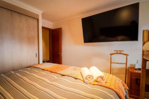 a bedroom with a bed with towels on it at HOM I SKI OUT 4PAX Edif Licancabur Valle Nevado 206A in Lo Barnechea