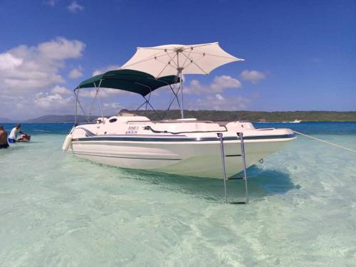 a boat with an umbrella in the water at Arena, Mar y Amaneceres para Siete frente a Farmatodo tucacas in Tucacas