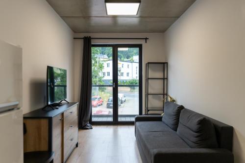 a living room with a couch and a tv at Apartamenty Przystanek Morska in Gdynia