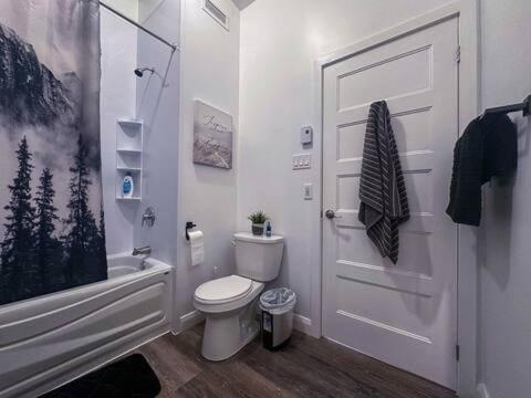a bathroom with a toilet and a shower and a door at Le St-Augustin - à 15 minutes des Outlets de Mirabel in Mirabel