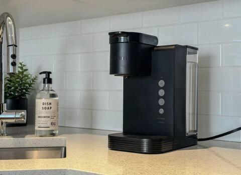 a black coffee maker sitting on a kitchen counter at Le St-Augustin - à 15 minutes des Outlets de Mirabel in Mirabel
