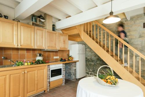 a kitchen with wooden cabinets and a staircase at Domaine Calmel & Joseph in Montirat