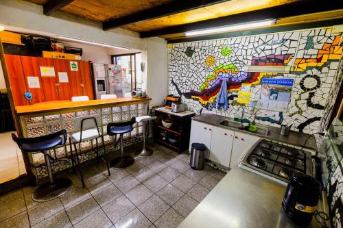 a kitchen with a counter and stools in it at Hostal Pampaloja Antof in Antofagasta