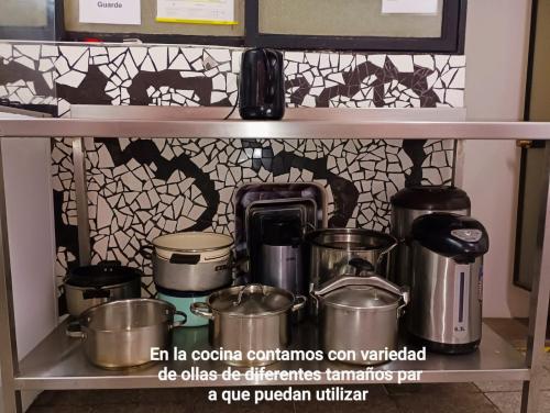 a shelf with pots and pans on it in a kitchen at Hostal Pampaloja Antof in Antofagasta